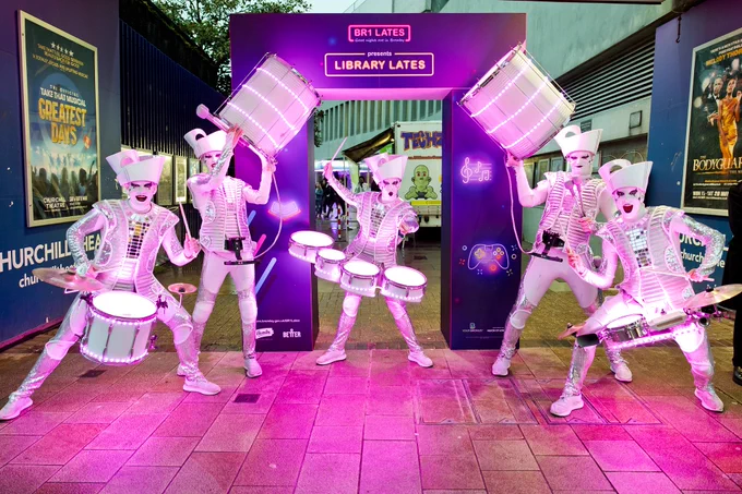 Spark drummers - Photo from Library lates in April, showing  5 Spark! Drummers in white face and outfits in front of the Library Lates arch at the entrance to Bromley Central Library.