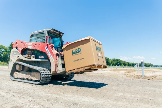 Skid Steer Loader, carrying an Array Technologies box