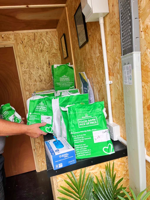 Mountains of green paper bags with “food bank pick up pack” printed on them.