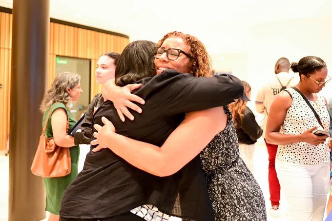 Generation Hope Founder and CEO Nicole Lynn Lewis smiles as she hugs a guest