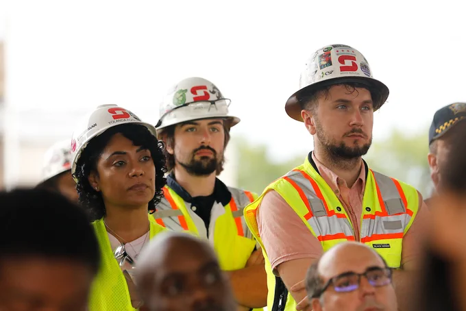 Photo ID: A group of construction workers stands together.