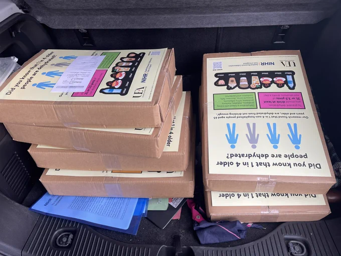 Boxes of posters in the back of a black car