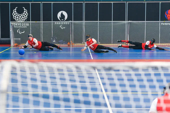 Goalball game in action -  3 male players defending a goal
