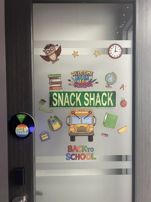 My office door with “snack shack” sign and back to school window stickers and decorations.