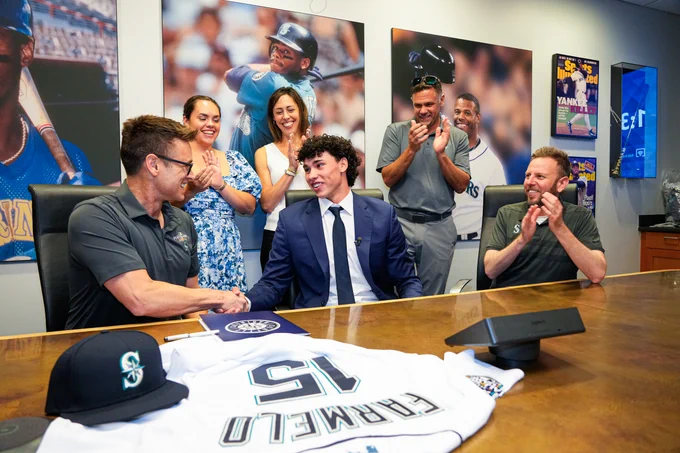 Photo of Jonny Farmelo shaking hands with Jerry Dipoto after signing his first Major League contract. 