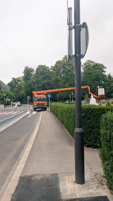 A cycling path blocked by a working truck with a mechanical arm
