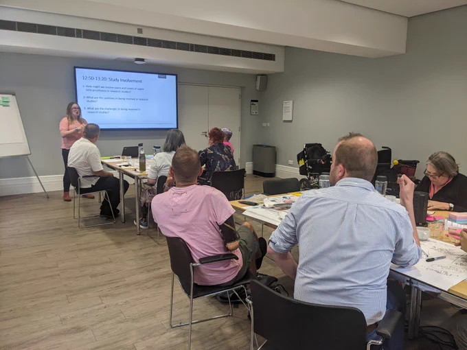 An image of a workshop with people looking towards a screen.