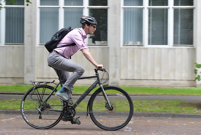 Person wearing smart clothes as they cycle to work