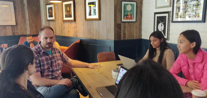 Group of people in a tech discussion. Four women and a man.