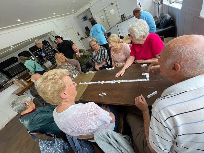 Group of participants playing domino’s around a large table