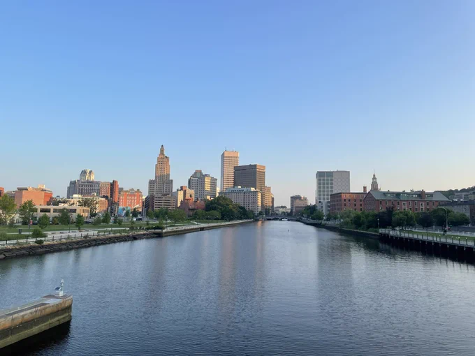 Sunrise view of downtown Providence with the river and tall buildings.
