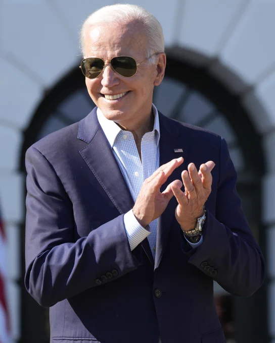 President Biden wearing sunglasses, clapping and smiling