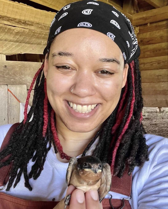 Murry smiles while holding a barn swallow.