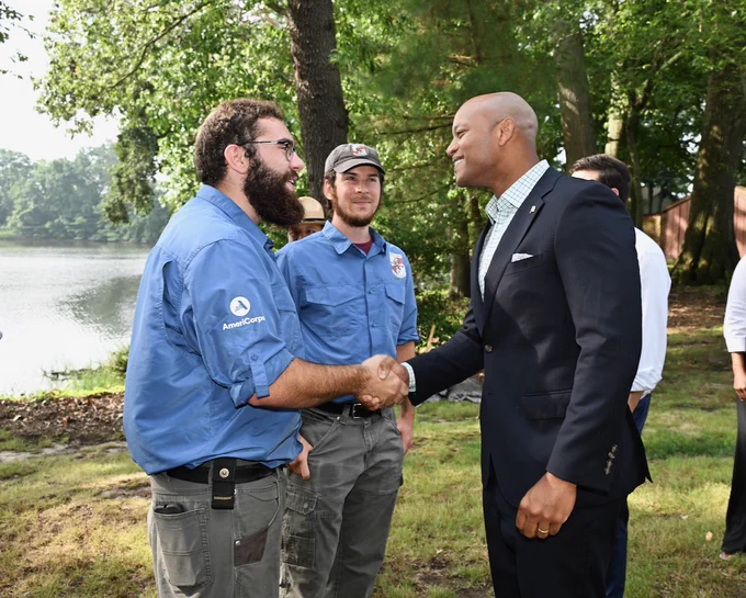 Photo of Governor Moore shaking hands with AmeriCorp staffer.