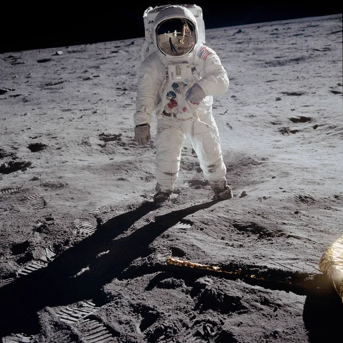 Buzz Aldrin on the Moon in a photograph taken by Neil Armstrong, who can be seen in the visor reflection along with Earth, the Lunar Module Eagle, and the U.S. flag.