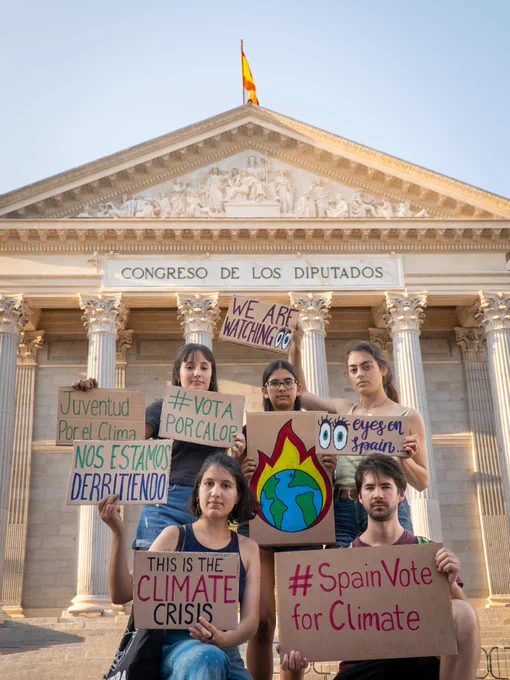 Photo of activists in front of the "Congreso de los Diputados" in Spain holding signs about the spanish elections and climate change 