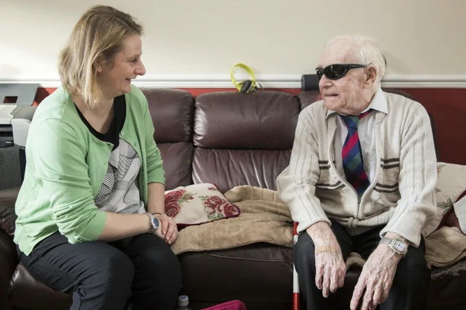A deafblind person speaking to a volunteer