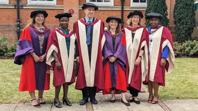 A photo of PhD graduates and professors in their graduation gowns