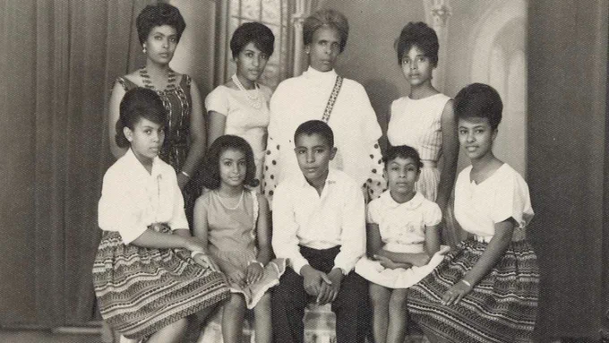 The Dawit family, eight members, sits for a family portrait, with Sally on the far left