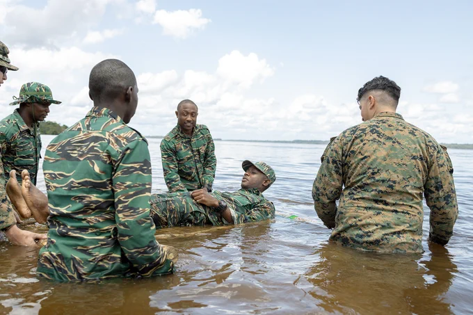 U.S. Marines with Fox Company, 2nd Battalion, 25th Marine Regiment and military members from Guyana Defence Force create improvised flotation devices using different techniques taught in Jungle Amphibious Training School (JATS) during Tradewinds 23 at the Jungle Area Training Site, Guyana, July 16, 2023. Tradewinds is a U.S. Southern Command-sponsored exercise designed to strengthen partnerships and interoperability, promote human rights, as well as increase all participants' training capacity and capability to mitigate, plan for and respond to crises and security threats. (U.S. Marine Corps photo by. Cpl. Ryan Schmid)