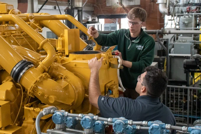 Student Ben Elick (top) and graduate researcher Justin Bayer work on the Caterpillar natural gas engine at CSU’s Powerhouse Energy Campus.