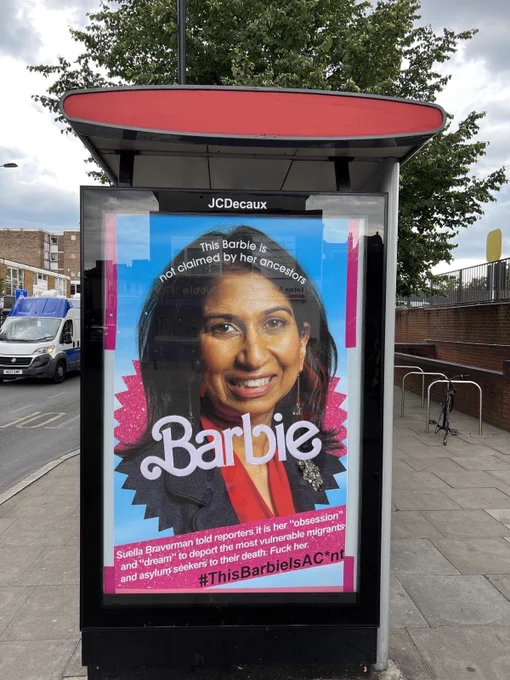 Picture of bus stop poster of mimicking Barbie movie marketing with Suella Braverman. Text on poster reads “This Barbie is not claimed by her ancestors.” “Suella Braverman told reporters it is her “obsession” and “dream” to deport the most vulnerable migrants and asylum seekers to their death. Fuck her. #ThisBarbieIsAC*nt”