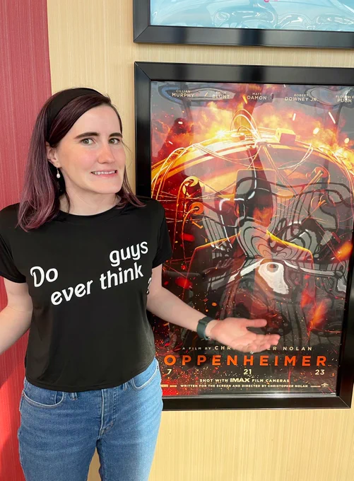 Emily wearing a black shirt that says “do guys ever think”