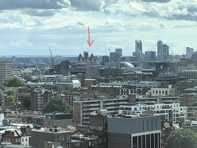View of central London with blocks of flats and skyscrapers. In the distance is the top of Tower Bridge.