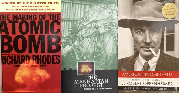 Photo of covers of 3 books about the atomic bomb: The Making of the Atomic Bomb (1986) by Richard Rhodes (red cover with atomic bomb explosion) & The Manhattan Project: Big Science and the Atom Bomb (2003) by Jeff Hughes (green cover with photo of “partially assembled gadget”) & American Prometheus: The Triumph and Tragedy of J. Robert Oppenheimer (2005) by Kai Bird and Martin J. Sherwin (photo of Oppenheimer on cover).