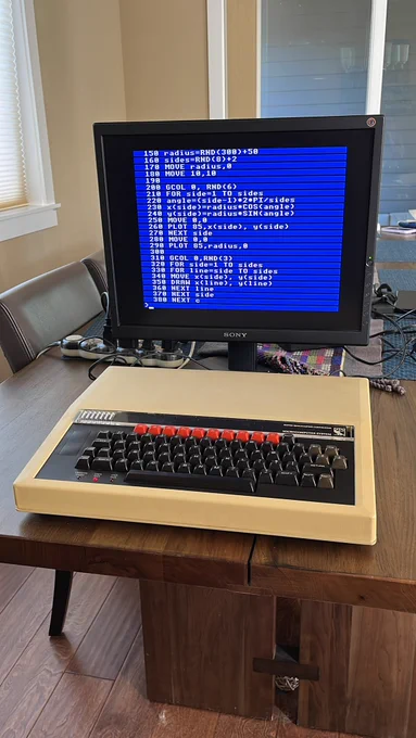 A BBC Model B computer with a BASIC a program listing on the attached monitor