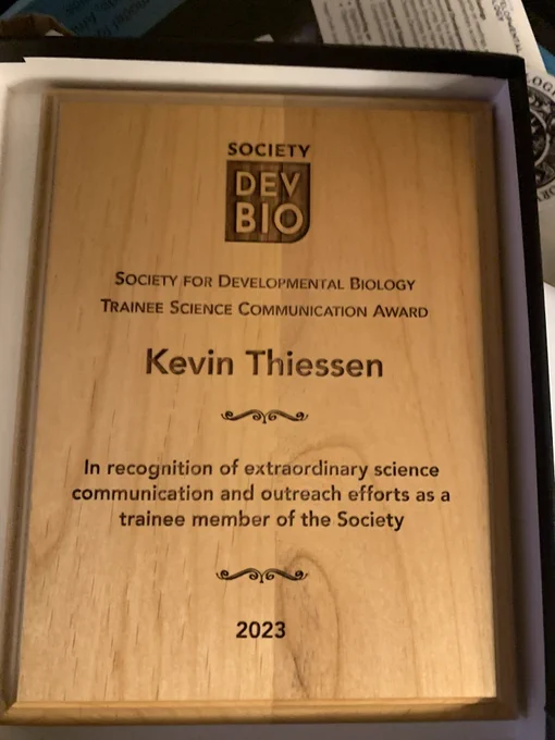 Plaque with the inscription that reads: Society for Developmental Biology Trainee Science Communication Award. Kevin Thiessen. In recognition of extraordinary science communication and outreach efforts as a trainee member of the Society. 2023.