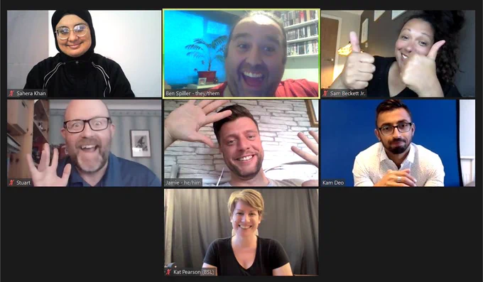 A diverse group of seven people on zoom. They smile, wave, and put up their thumbs.