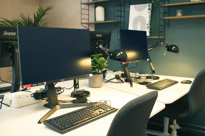 Office space with desk, chairs, and computer monitors.