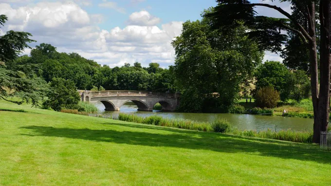 River with vivid green grass and trees around it.