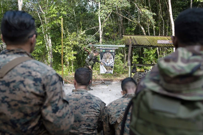 U.S. Marines with Fox Company, 2nd Battalion, 25th Marine Regiment, 4th Marine Division, Marine Forces Reserve, military members from Guyana Defence Force and a military member from Trinidad and Tobago Defence Force, learn about collecting water and starting fires in Jungle Amphibious Training School during Tradewinds 2023 at Jungle Area Training Site, Guyana, July 22, 2023. (U.S. Marine Corps photo by. Cpl. Ryan Schmid)