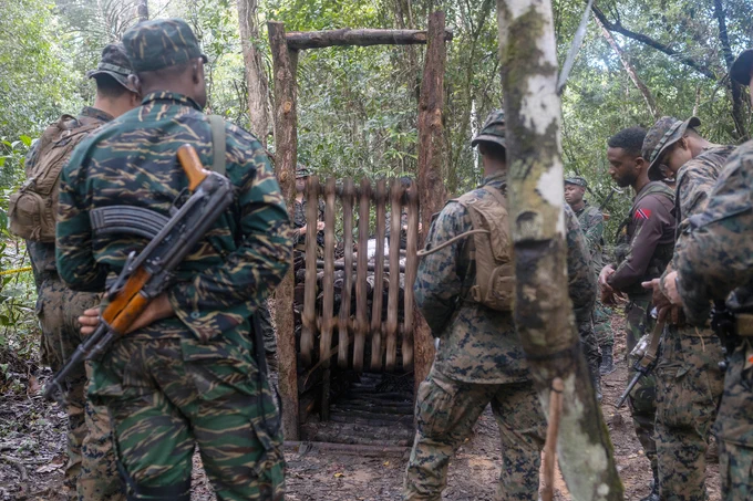 U.S. Marines with Fox Company, 2nd Battalion, 25th Marine Regiment, 4th Marine Division, Marine Forces Reserve, military members from Guyana Defence Force and a military member from Trinidad and Tobago Defence Force, learn about creating traps in Jungle Amphibious Training School during Tradewinds 2023 at Jungle Area Training Site, Guyana, July 22, 2023. (U.S. Marine Corps photo by. Cpl. Ryan Schmid)