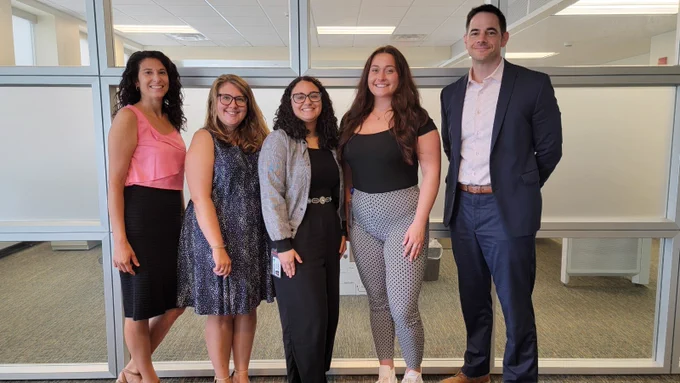 New York State Office of General Services Human Resources Team members pose for a photo with a student intern at the Business Services Center on National Intern Day.