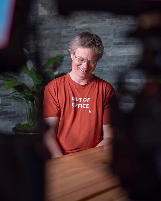 Photo of John Hammersley smiling and looking down during an interview