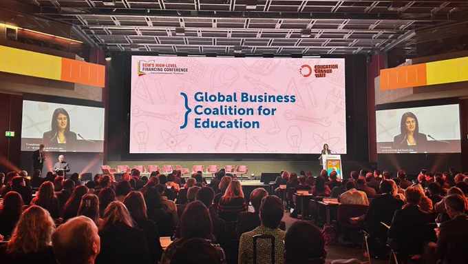 An image of Head of Business Impact at the Global Business Coalition for Education, Emily Friedman, delivering a talk at a conference, to a very large audience.