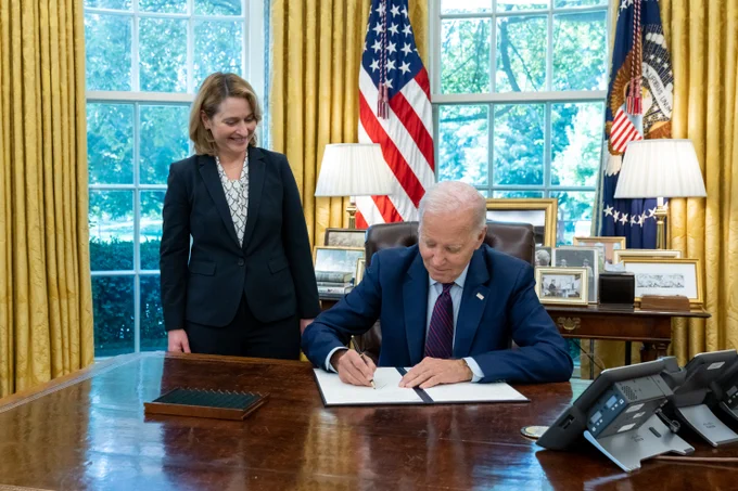 President Biden, joined by United States Deputy Secretary of Defense Kathleen H. Hicks, signs an Executive Order in the Oval Office.