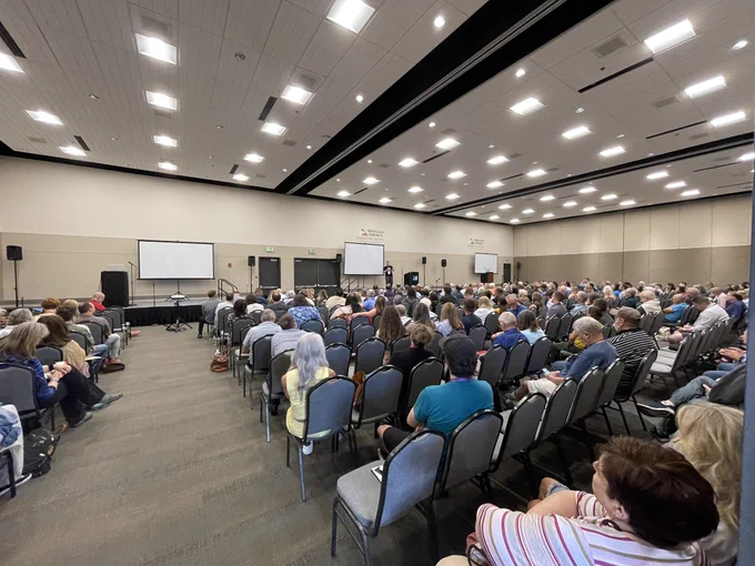 Large convention center filled with people.