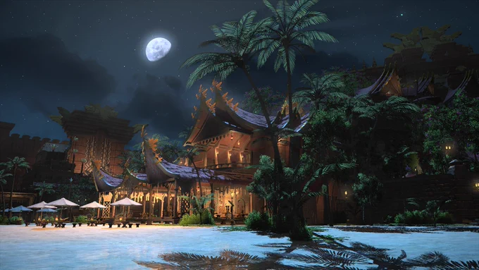 A screenshot of Tuliyollal at night. A large, brightly-lit beachside house stands under the moonlight, partially shrouded by palm trees.
