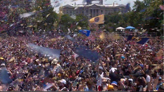 Confetti falls on a crowd of Denver Nuggets fans celebrating a NBA championship.