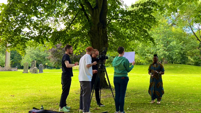 Film crew capturing  Khadijah Ibrahiim reciting poetry  in St George’s Field at the University of Leeds.