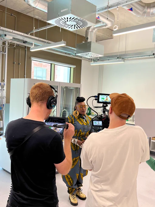 Film crew capturing  Khadijah Ibrahiim reciting poetry in a laboratory in the Bragg building at University of Leeds.