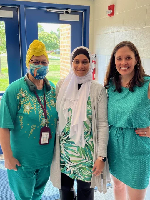 Image of three women all wearing turquoise. 