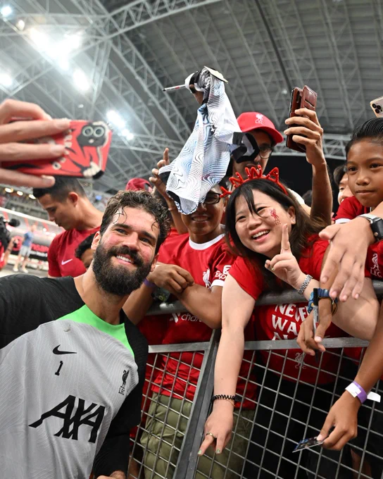 Alisson taking a selfie with a fan after today's training session in Singapore. 