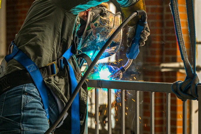 Erin Kelley in helmet welding railing 