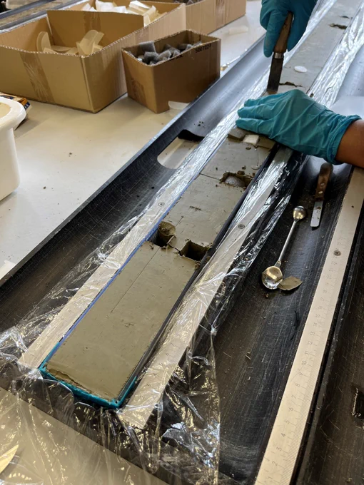 A scientist cuts a sample out of a sediment core.