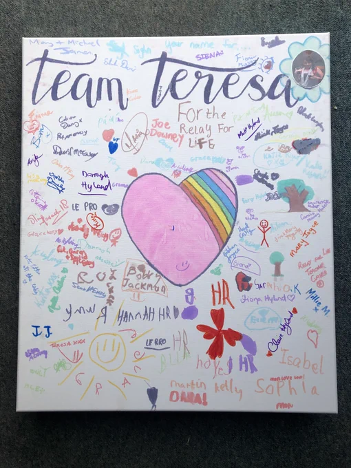 A large canvas with a colourful heart at the centre and lots of signatures of the Team Teresa members. 